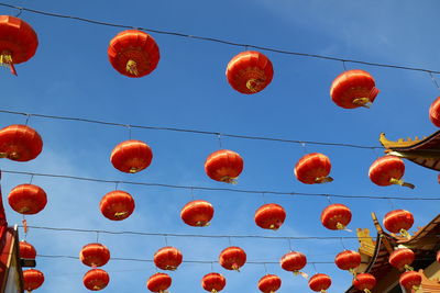 Low angle view of lanterns hanging against sky