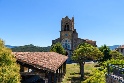 Temple by building against clear blue sky