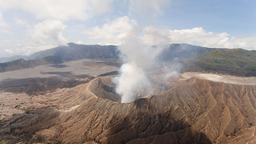 Smoke emitting from volcanic mountain against sky