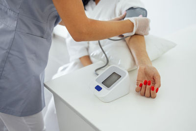 Midsection of doctor examining patient in clinic