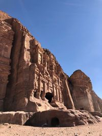 Low angle view of rocks on mountain against sky