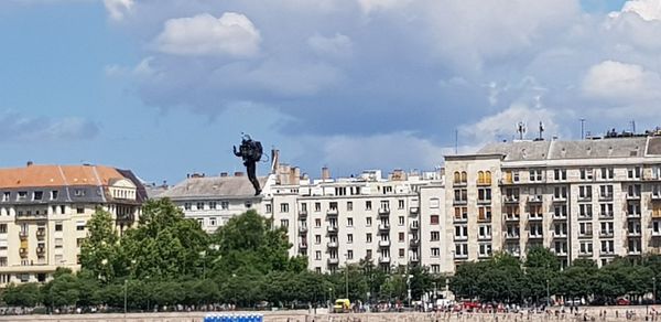 Buildings in city against cloudy sky