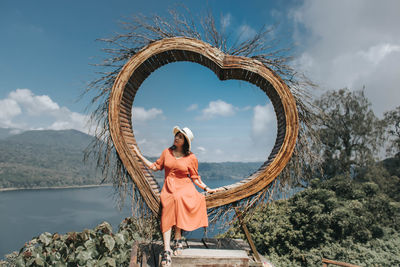 Pretty asian woman is sitting on straw nest, wanagiri hidden hill, bali.
