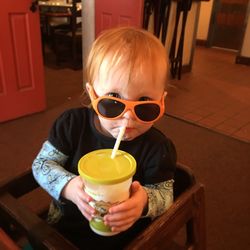 Portrait of baby girl drinking juice at home