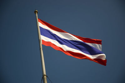 Low angle view of flag against blue sky