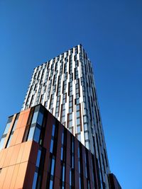 Low angle view of modern building against clear blue sky