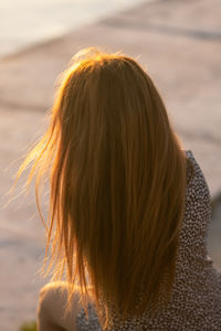 A beautiful girl admires the sunset, the girl's face is not visible