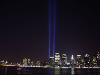 Illuminated cityscape against sky at night