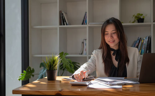 Young businesswoman working at table