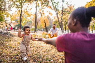 Side view of boy playing with daughter at park