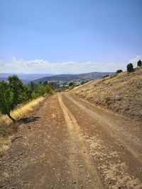 Road passing through landscape against sky