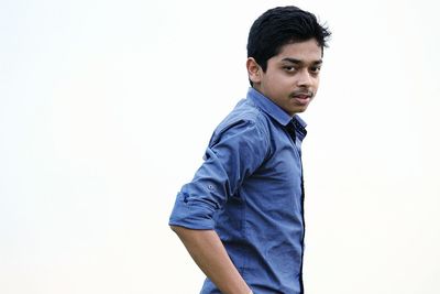 Portrait of young man standing against white background