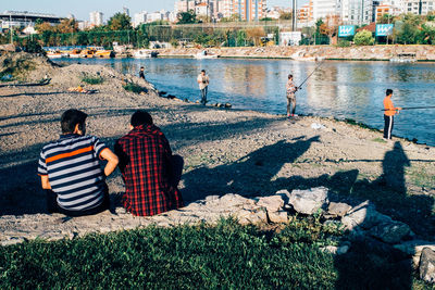 Rear view of couple sitting on water