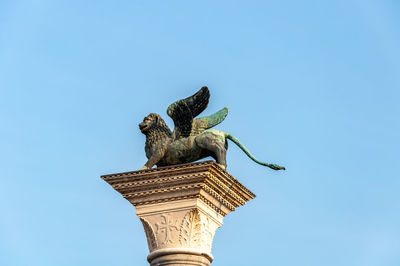 Low angle view of statue against blue sky