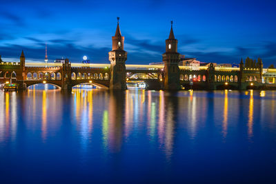 Bridge lit up at night and reflected in canal