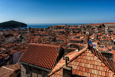 High angle view of townscape by sea against clear sky