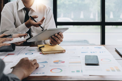 Midsection of business colleagues working on table