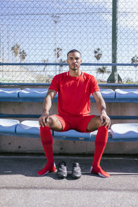 Portrait of african american male soccer player sitting on bench