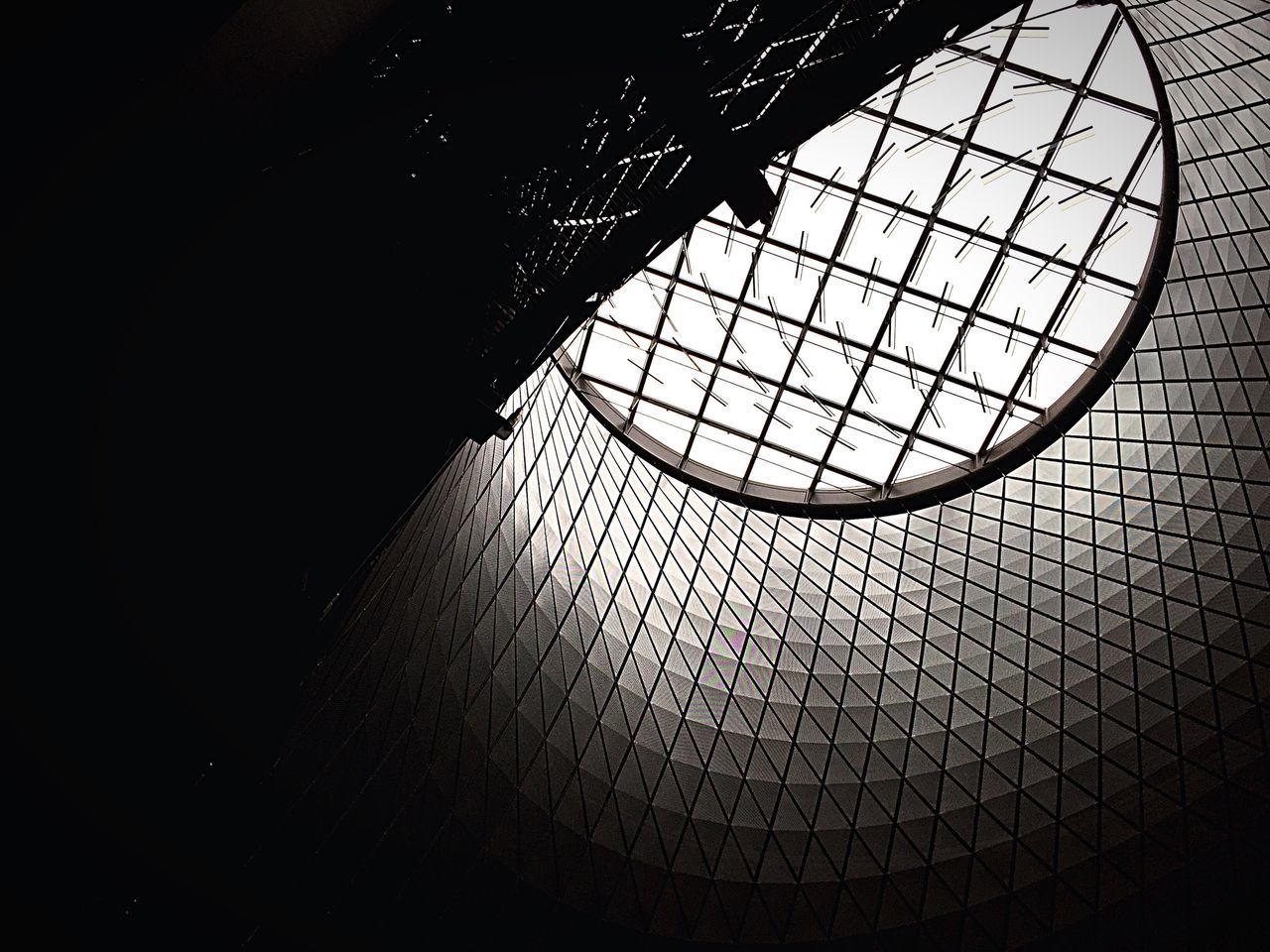 indoors, architecture, built structure, pattern, ceiling, window, low angle view, geometric shape, design, skylight, glass - material, building, wall - building feature, no people, architectural feature, metal, day, shadow, circle, sunlight