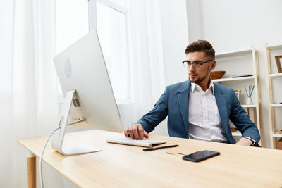 Side view of businessman working at desk in office