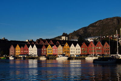 View of river by buildings against blue sky