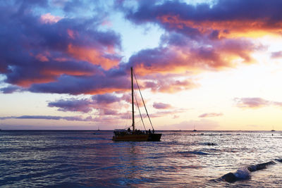 Sailboat in sea against sky during sunset