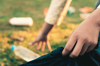 Midsection of man holding hands on field