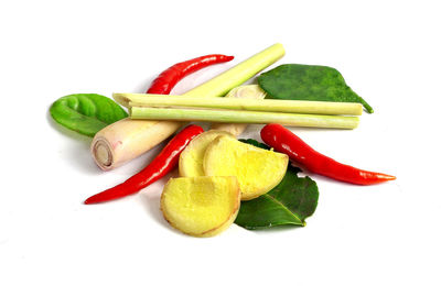Close-up of multi colored chili peppers against white background