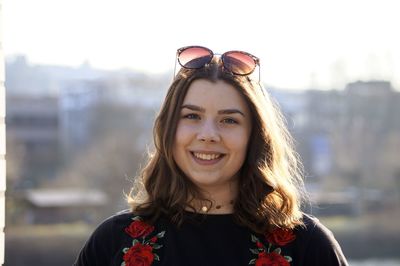 Close-up portrait of woman smiling while standing in city