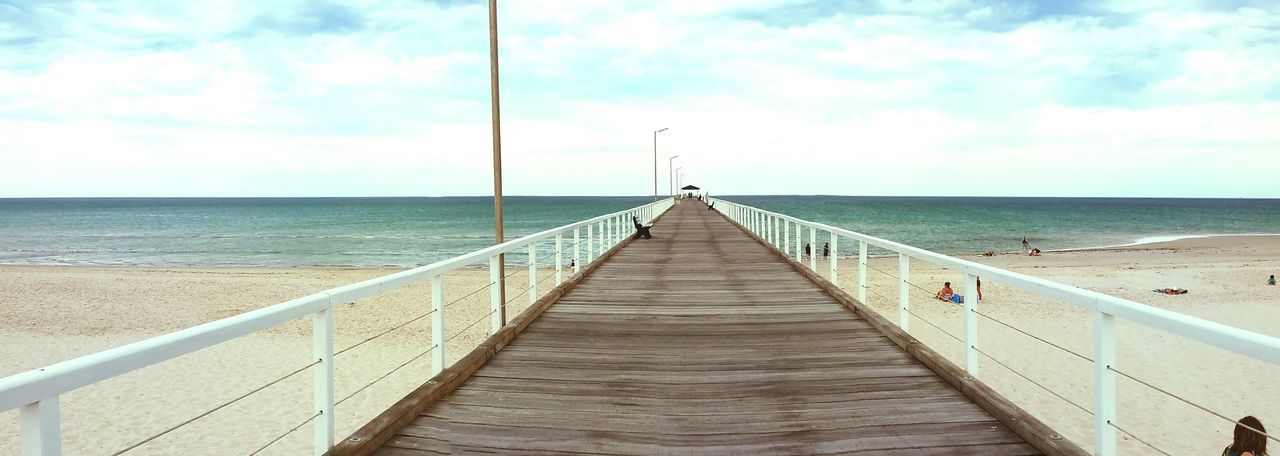 sea, horizon over water, the way forward, sky, water, diminishing perspective, railing, pier, tranquil scene, vanishing point, beach, tranquility, scenics, long, cloud - sky, beauty in nature, nature, cloud, blue, boardwalk