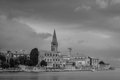 River in city against cloudy sky