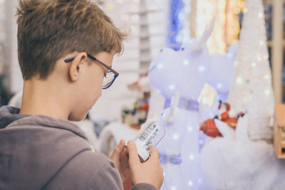 Pre-adolescent boy holding decoration at home