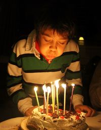Boy blowing candles on birthday cake