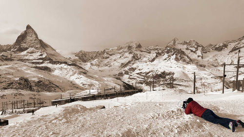 Full length of man lying on snow covered land during winter