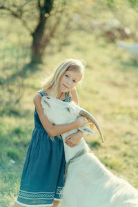 Farm girl playing with goat