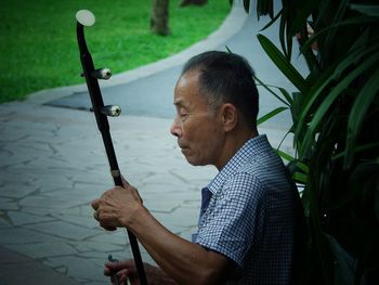 Close-up of senior man holding musical equipment