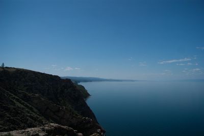 Scenic view of sea and mountains against blue sky