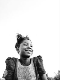 Portrait of a smiling young woman against clear sky