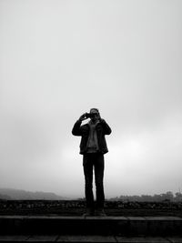 Full length rear view of man standing against sky