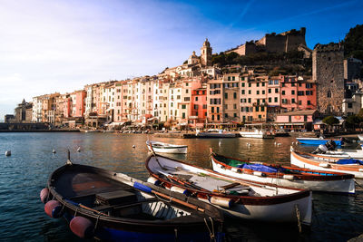 Boats moored in canal by buildings in city