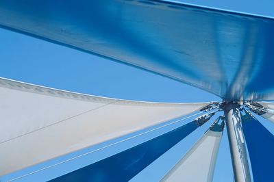 Low angle view of parasol against clear blue sky