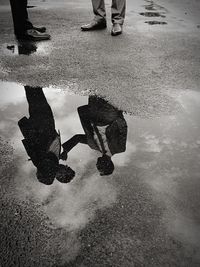 Reflection of people in puddle