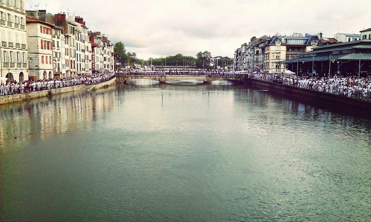 architecture, built structure, water, building exterior, waterfront, sky, river, bridge - man made structure, cloud - sky, city, canal, connection, reflection, incidental people, rippled, cloudy, building, day, bridge, outdoors