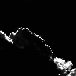 High section of silhouette trees against clouds