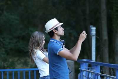 Side view of people photographing while standing at observation point