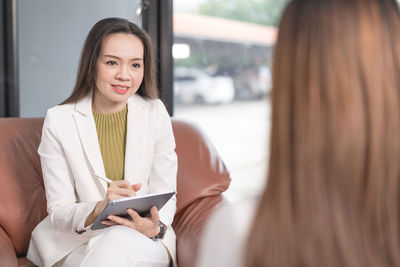 Young woman using smart phone in laptop