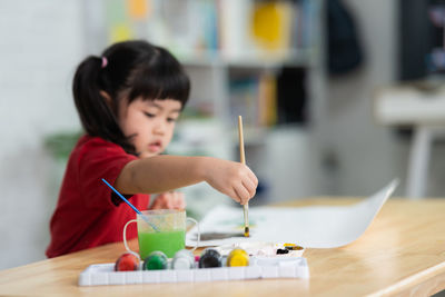 Close-up of girl painting on table