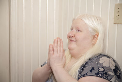 Portrait of woman against wall at home