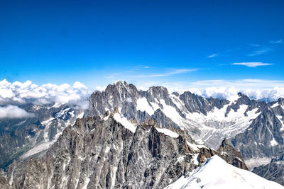 Scenic view of snowcapped mountains against blue sky