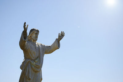 Low angle view of jesus statue against clear sky